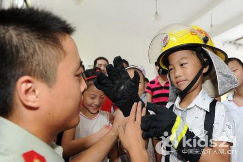 一名小朋友穿上消防服，感受消防战士的生活