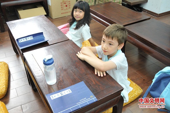 7月28日，北京国子监成贤国学馆经典诵读暑期班的孩子正在上课。图为一名可爱的外国籍小男孩儿在认真听老师讲课。中国文明网 谢小燕 摄 