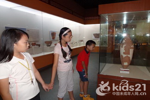 小学生正在观赏仰韶文化半坡类型的典型汲水容器《小口尖底瓶》