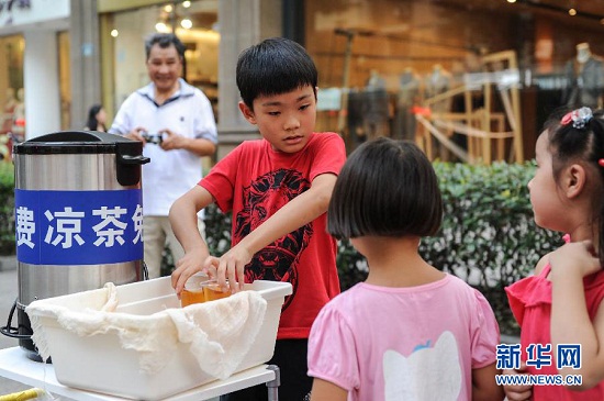 8月19日，阮天杰为路过的两个小朋友送上凉茶。