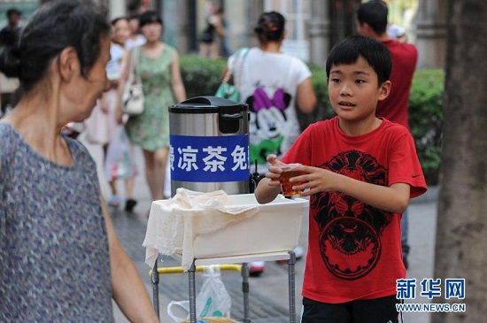 8月19日，阮天杰为一位路过的老人送上凉茶。