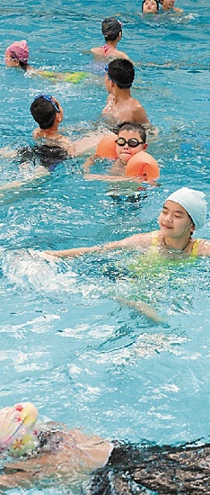 暑假以来，不少孩子忙着学游泳。李小波 摄