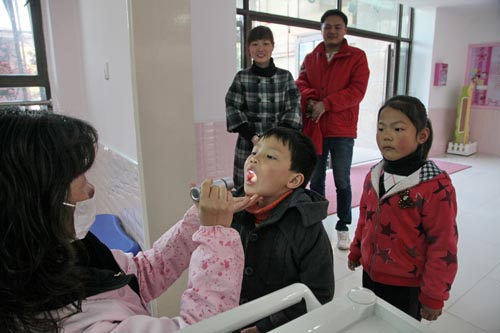 　4月8日，在上海市金山区新城幼儿园，值班卫生老师在对刚入园的幼儿进行晨间检查。