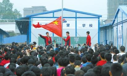5月6日,芦山中学的同学们在已经建成的板房教室边举行升旗仪式
